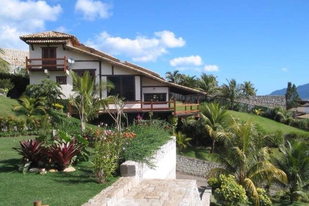 uma casa numa colina com um jardim em Casa Yacht Club em Ilhabela