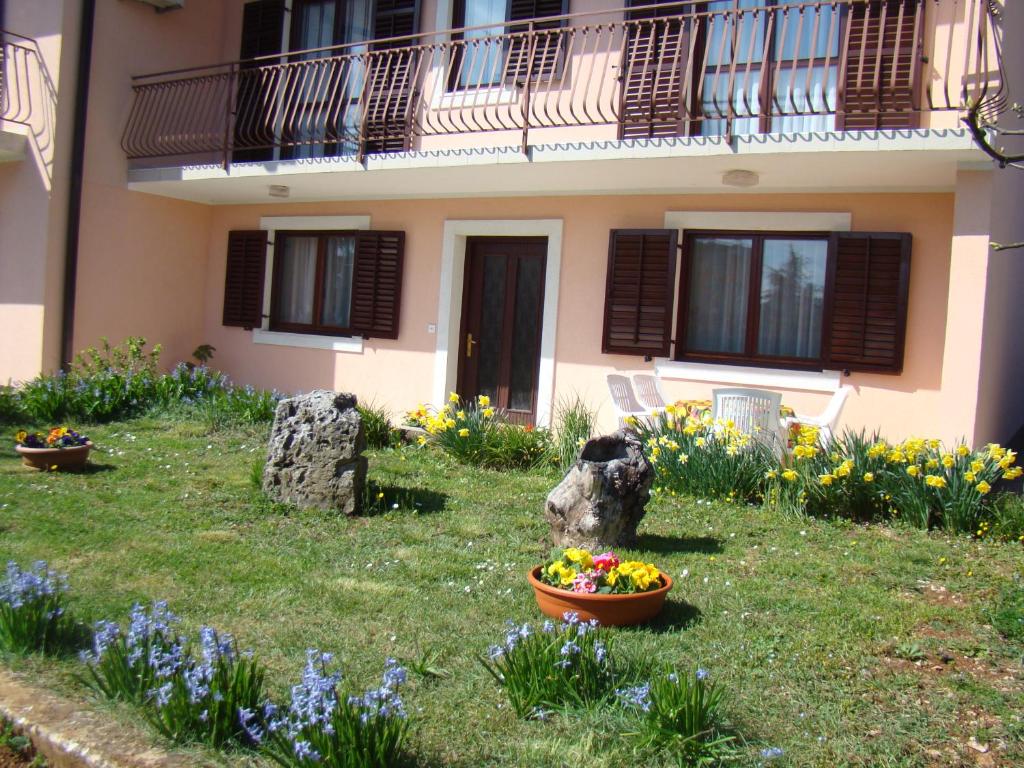 a house with flowers in the front yard at Apartman Poldrugovac in Labin
