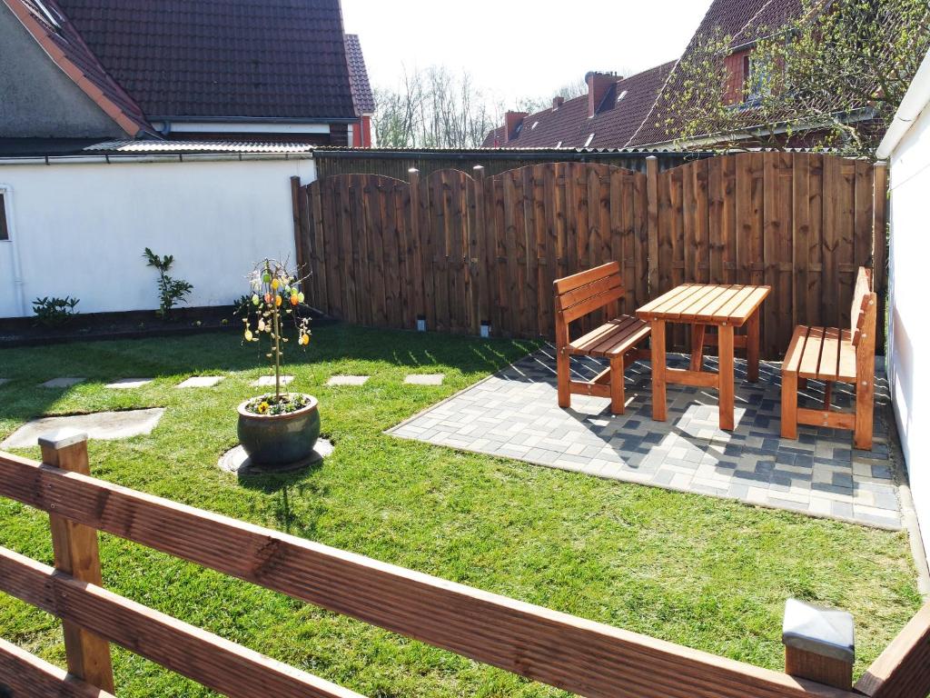 a backyard with a table and two chairs and a wooden fence at Fischerhaus Bremerhaven in Bremerhaven
