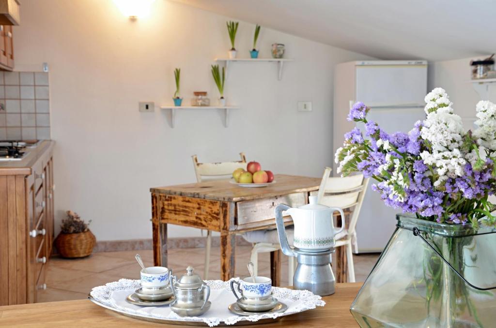 una cocina con una mesa con un jarrón de flores en Anemone Guest House, en Santa Maria Navarrese