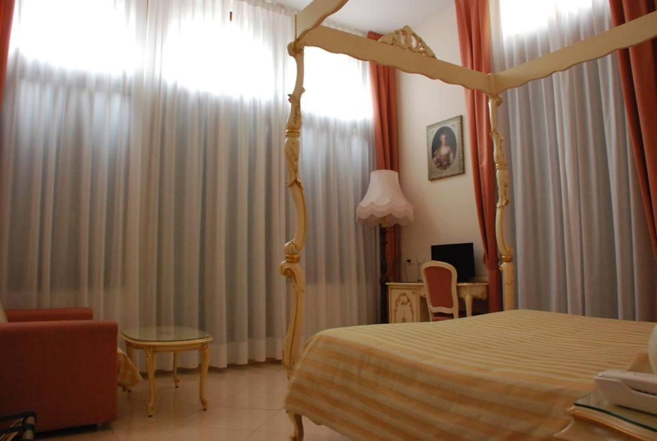 a bedroom with a canopy bed and a table and chairs at Hotel Marte in Venice