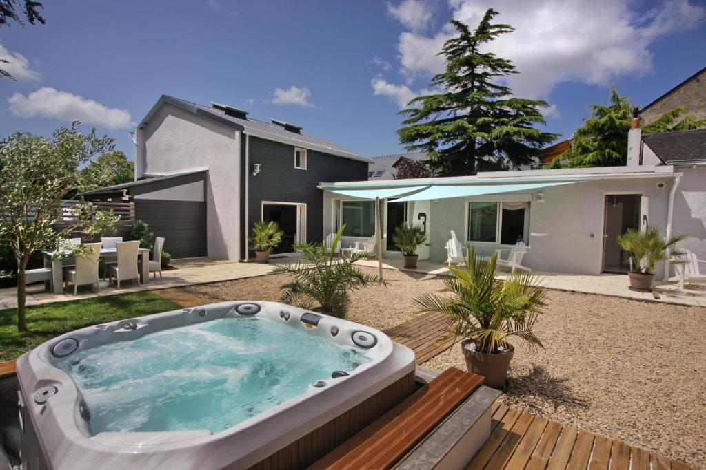 La Maison au-dessus des Voiles في لا بول: حديقة خلفية مع حوض استحمام ساخن على سطح خشبي