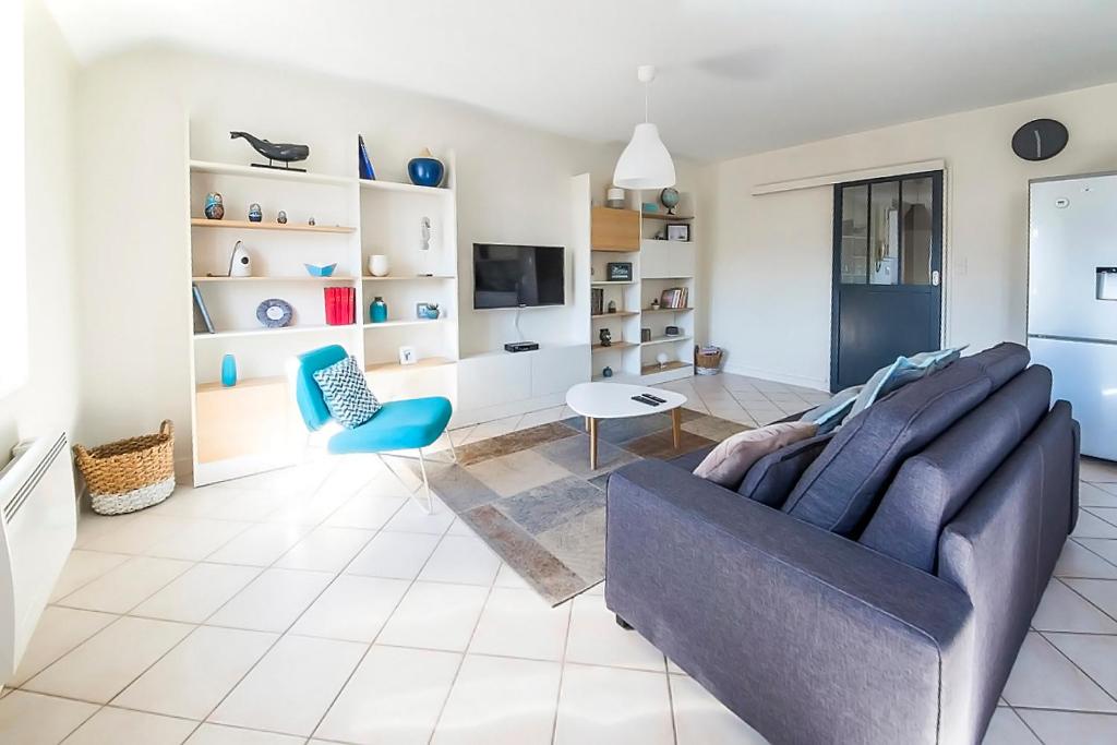 een woonkamer met een bank en een tv bij Ocean Apartment in Saint-Malo
