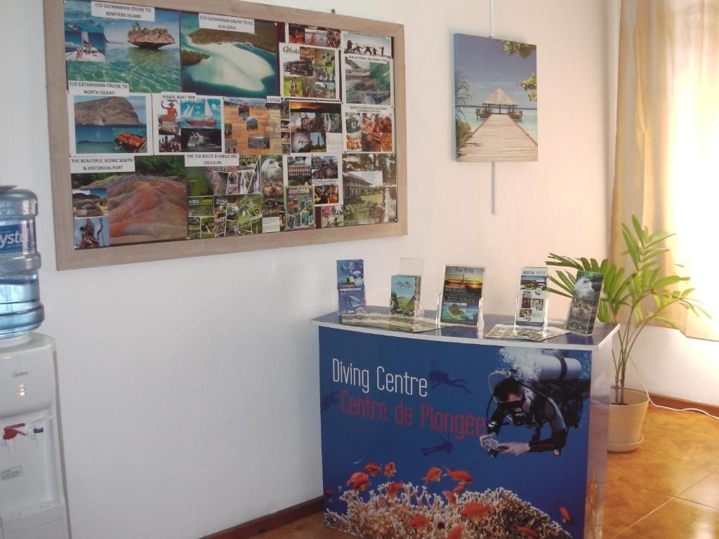 a table in a room with pictures on the wall at Welcome Holidays in Grand Baie