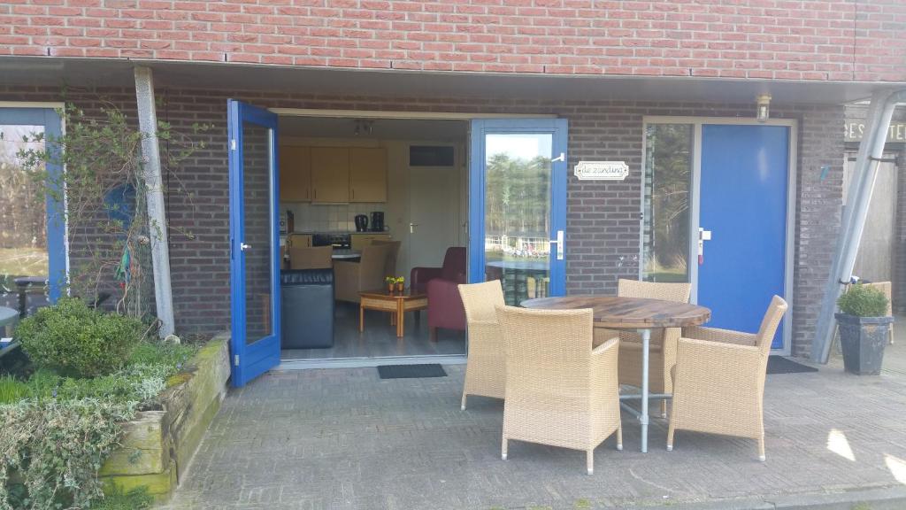 a patio with a table and chairs and a kitchen at de Zanding in Oost-Vlieland