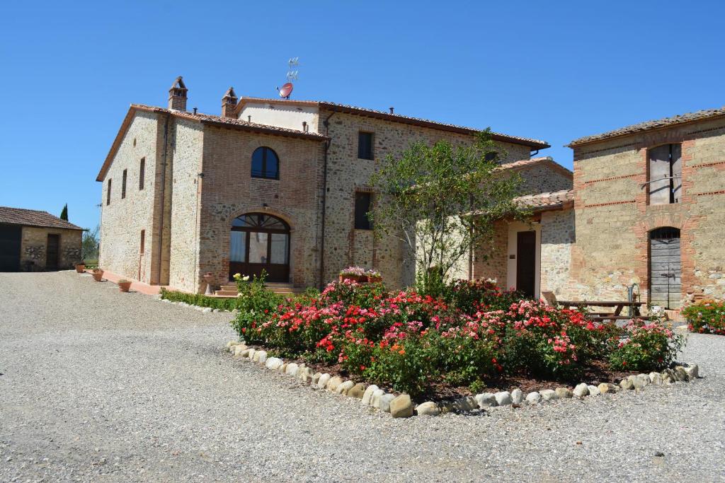 a building with a bunch of flowers in front of it at Agriturismo Melariano in Castelnuovo Berardenga