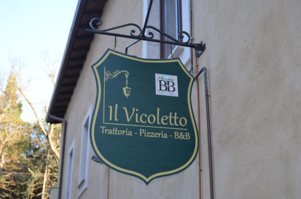 a sign for a restaurant on the side of a building at B&B Il Vicoletto in LʼAquila