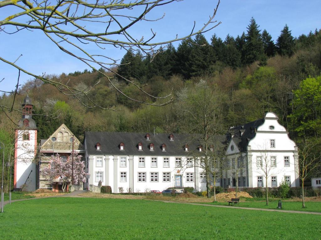 ein großes weißes Gebäude mit schwarzem Dach in der Unterkunft Gästehaus der Abtei Sayn in Bendorf