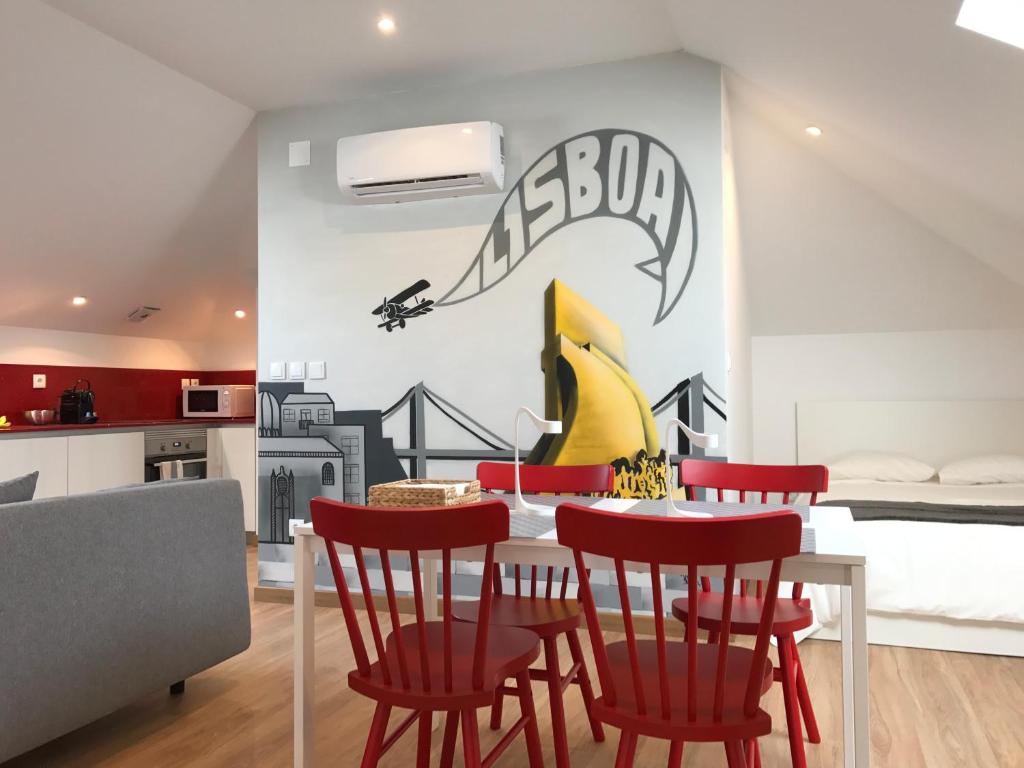 a kitchen and dining room with a table and red chairs at Home Out Rooms & Apartments in Lisbon
