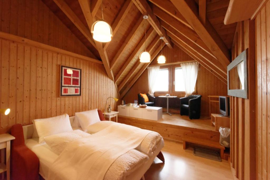 a bedroom with a large bed and a living room at BnB Alpenblick in Lütisburg