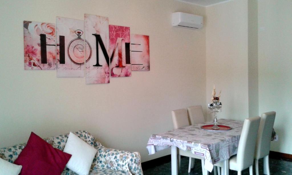 a dining room with a table and a sign that reads home at Cristina Apartment in Verona