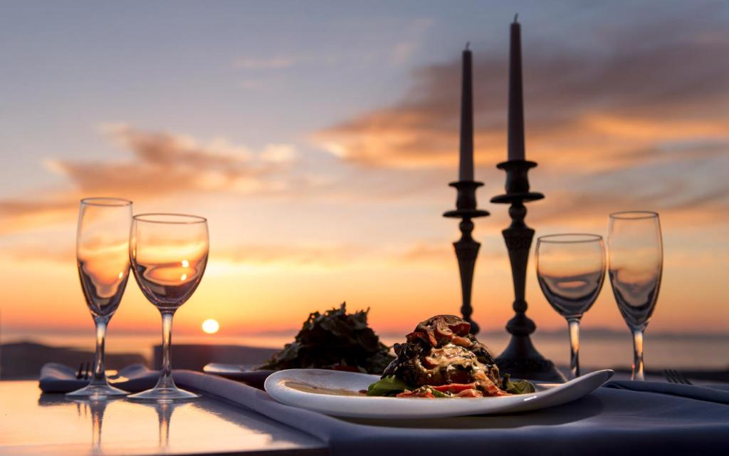une table avec une assiette de nourriture et trois verres à vin dans l'établissement Art Riad Au Bord De La Mer, à El Jadida