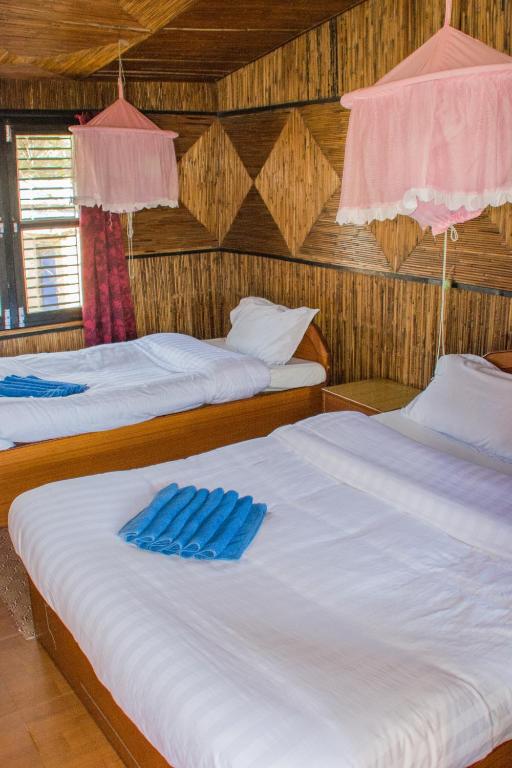 Postel nebo postele na pokoji v ubytování Chitwan Tiger Camp
