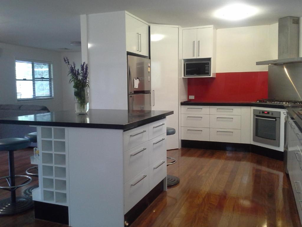 a kitchen with white cabinets and a black counter top at Stay @ LP Montville in Montville