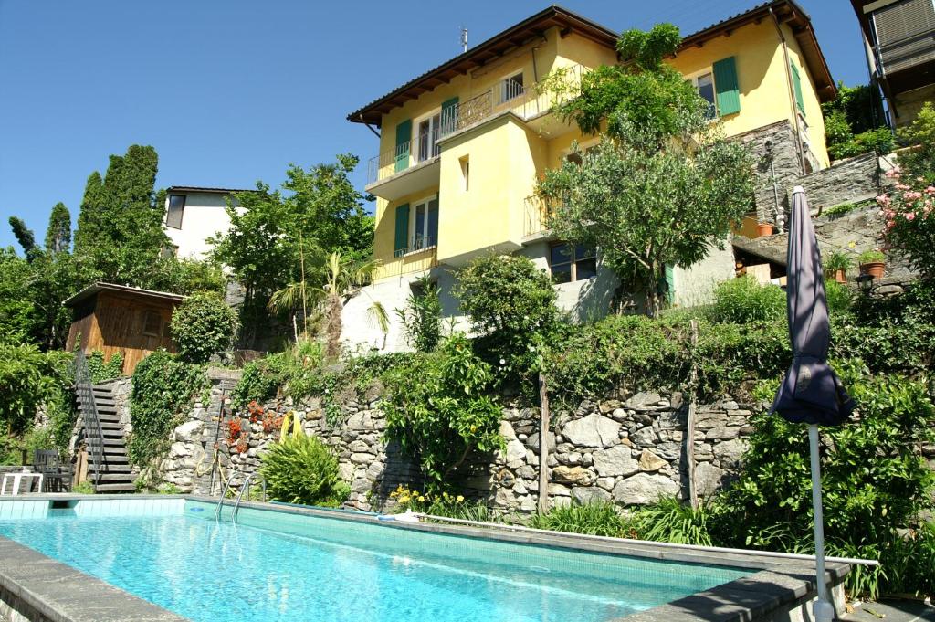 un hotel con piscina frente a un edificio en Casa Aries & Studio Aurora, Cavigliano, en Cavigliano