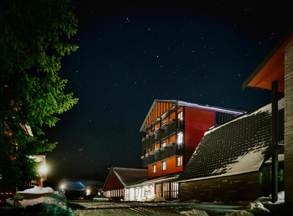 a building at night with snow on the ground at Rondane Høyfjellshotell in Mysusæter