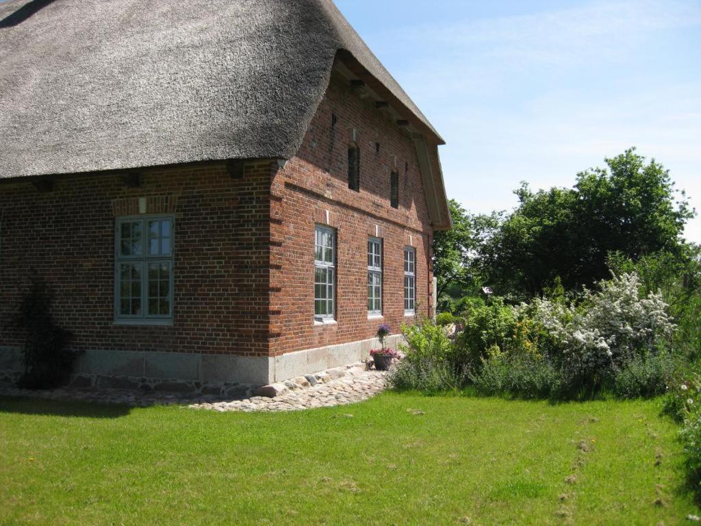 an old brick building with a thatched roof at Apartments Golden Tüffel in Hohwacht