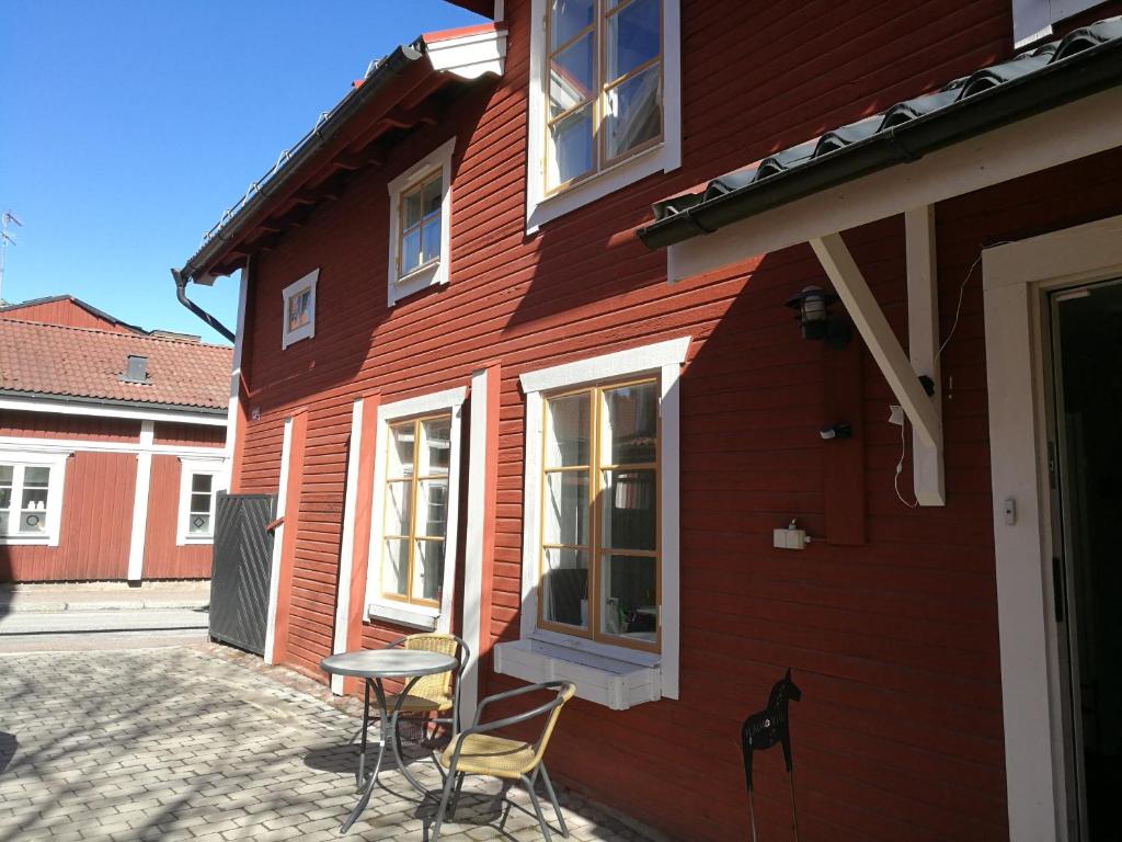 ein rotes Haus mit Stühlen und einem Tisch davor in der Unterkunft Kopparstugans Bed & Breakfast in Falun