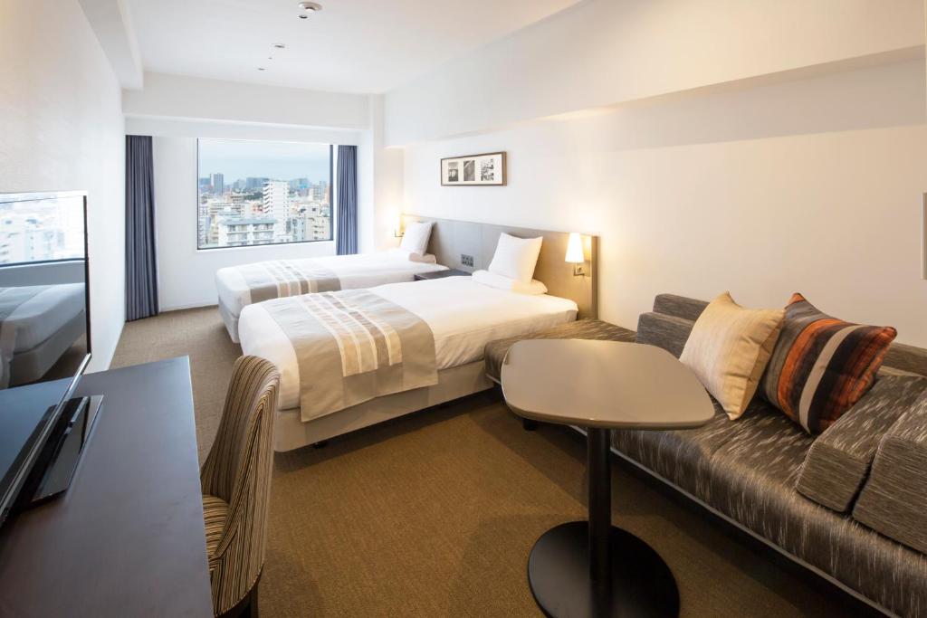a hotel room with a bed and a couch at HOTEL MYSTAYS PREMIER Omori in Tokyo