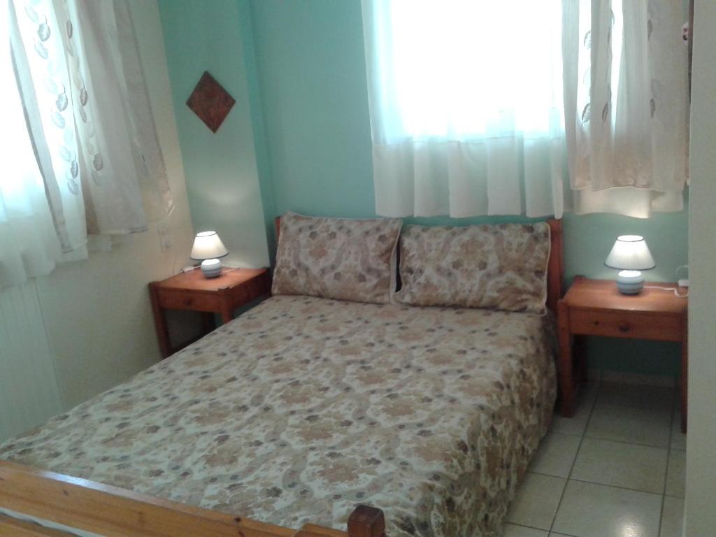 パトラにあるThomais Apartmentのベッドルーム1室(ベッド1台、ランプ2つ、テーブル2台付)