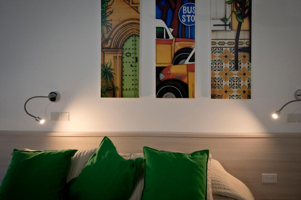 ein Wohnzimmer mit einem Sofa und zwei Gemälden an der Wand in der Unterkunft Apartment 81 in Mosta