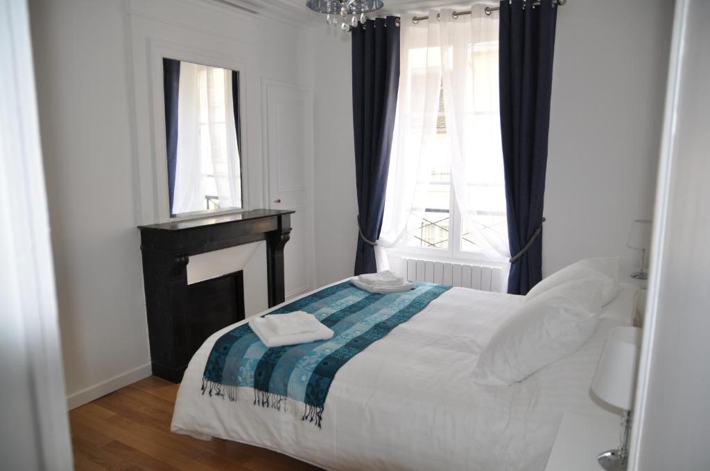 1 dormitorio con 1 cama con 2 toallas en Résidence du Cygne - Swan Residence - Paris centre en París