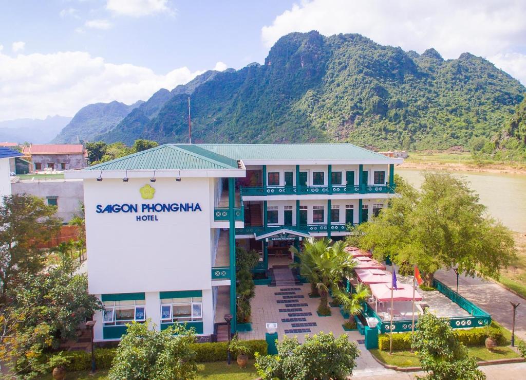 a building with a sign in front of a mountain at Sai Gon Phong Nha Hotel in Phong Nha