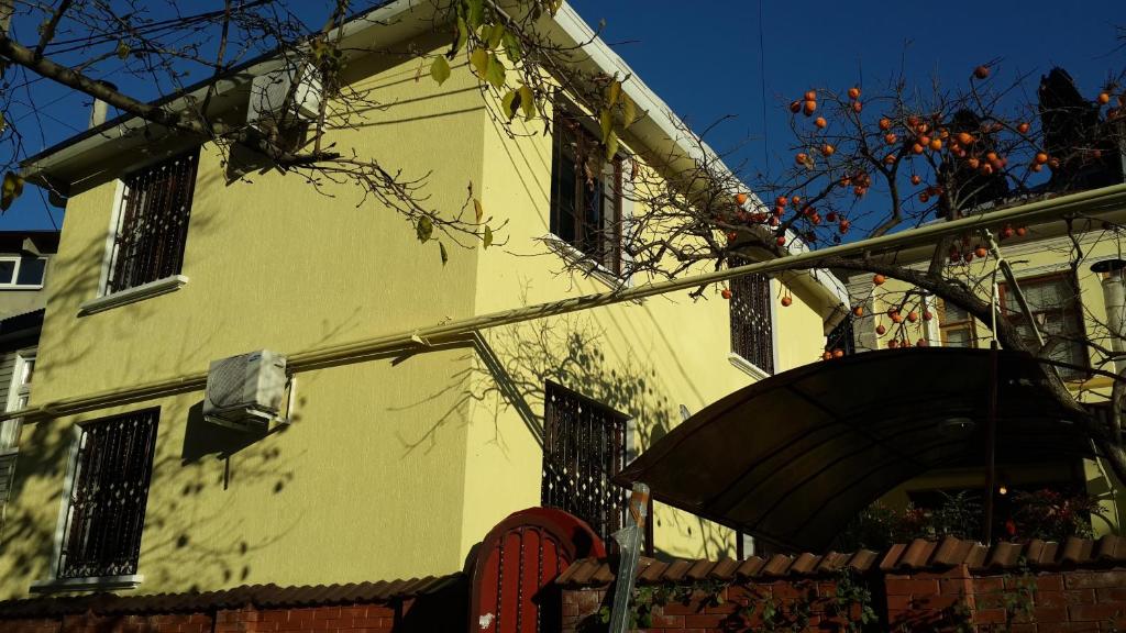ソチにあるGuest house on Griboyedova 3の木の目の前の黄色い建物