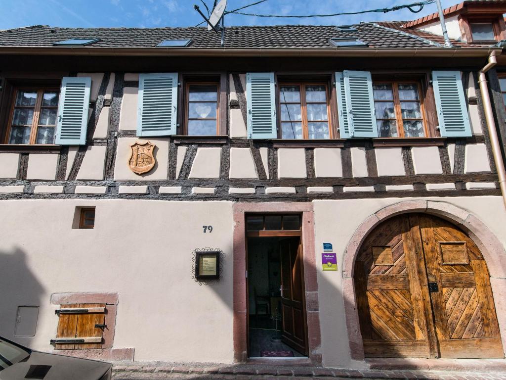 uma casa antiga com portas e janelas de madeira em Gîtes Strengbach em Ribeauvillé