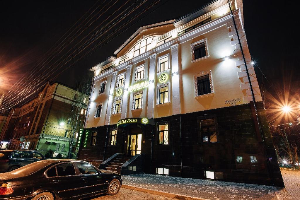 un coche aparcado delante de un edificio por la noche en Golden Plaza Hotel, en Tver