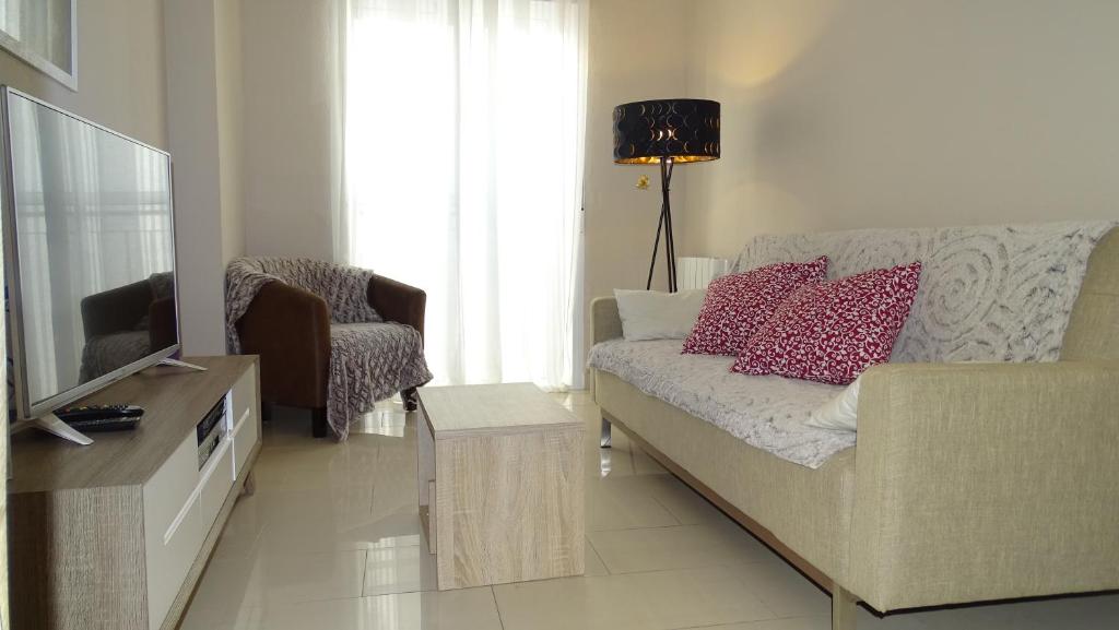 a living room with a couch and a television at Cosy Caleta Apartment in Cádiz