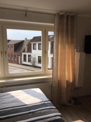 Schlafzimmer mit einem großen Fenster und einem Bett in der Unterkunft Apartment Kleine Kremper in Glückstadt