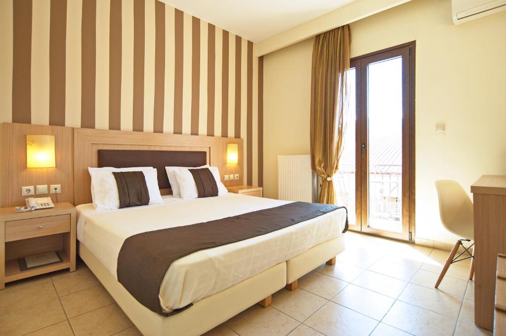 a hotel room with a large bed and a window at Hotel Leto Delphi in Delfoi