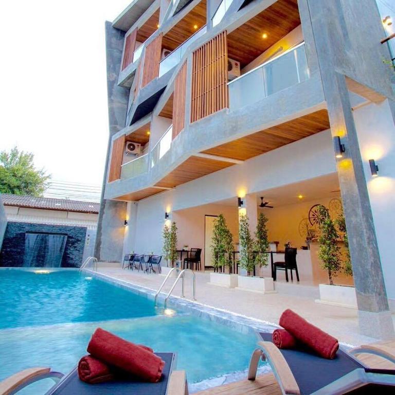a house with a swimming pool and a dining area at Lemonade Phuket Hotel -SHA Plus in Chalong