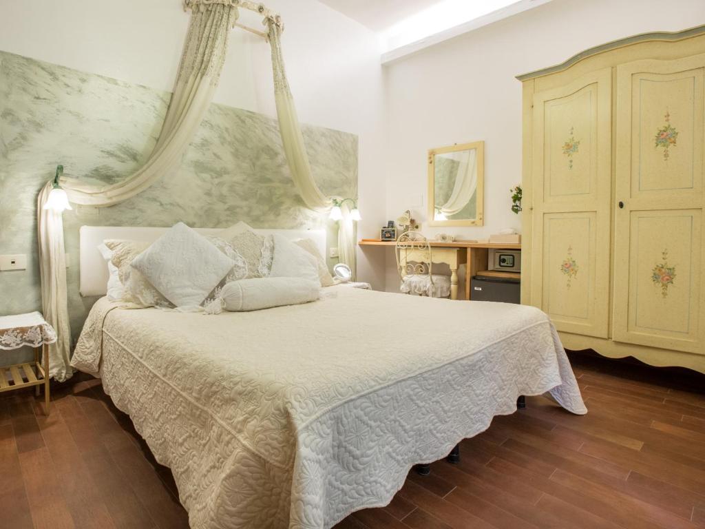 a bedroom with a large white bed with a canopy at Hotel Marina in Monterosso al Mare