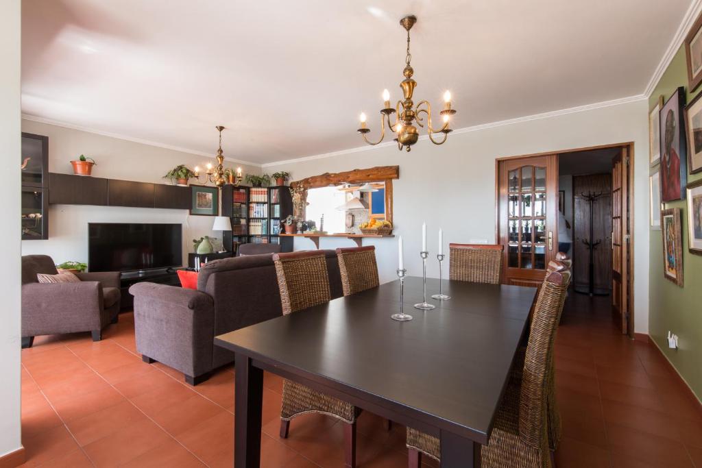 een eetkamer en een woonkamer met een tafel en stoelen bij "HomeySuite" in Estoril Beach Apartment in Estoril
