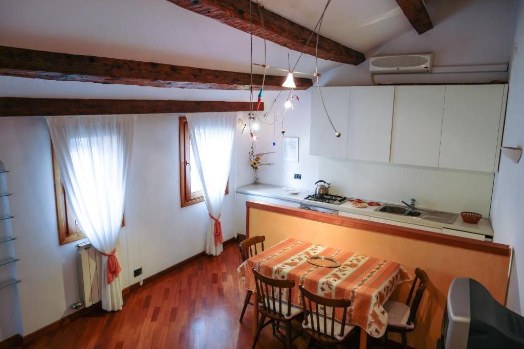 - une cuisine et une salle à manger avec une table et des chaises dans l'établissement Cà Marina, appartamento in Biennale, à Venise