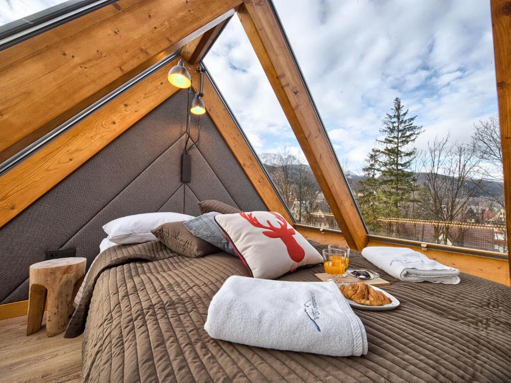 a bed in a room with a large window at VisitZakopane - Mont Blanc Apartment in Zakopane