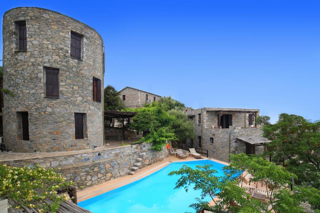 vista para uma piscina em frente a um edifício em Pyrgos Traditional Village em Agios Kirykos