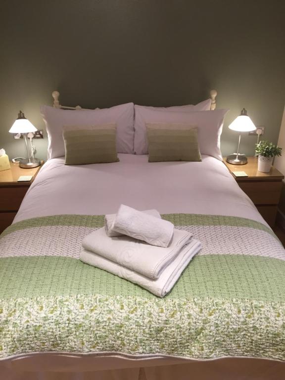 a large white bed with two towels on it at Number 10 Serviced Apartment - City Center in Southampton
