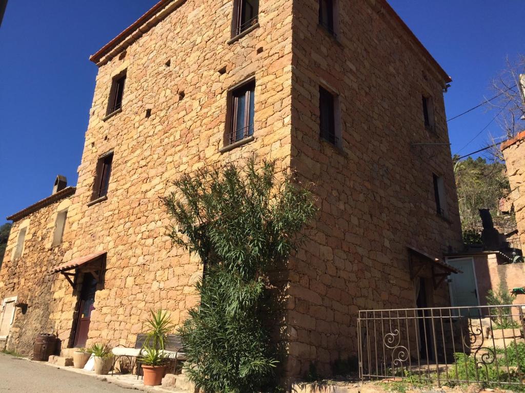 an old brick building with a stone wall at L'Alivi in Serriera