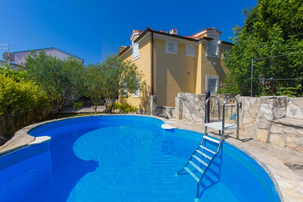 a pool with blue water in front of a house at Vila Jadranka in Vodice