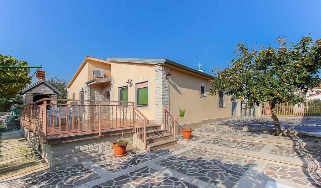 a house with a porch and a staircase in front of it at Apartments Vlah in Medulin