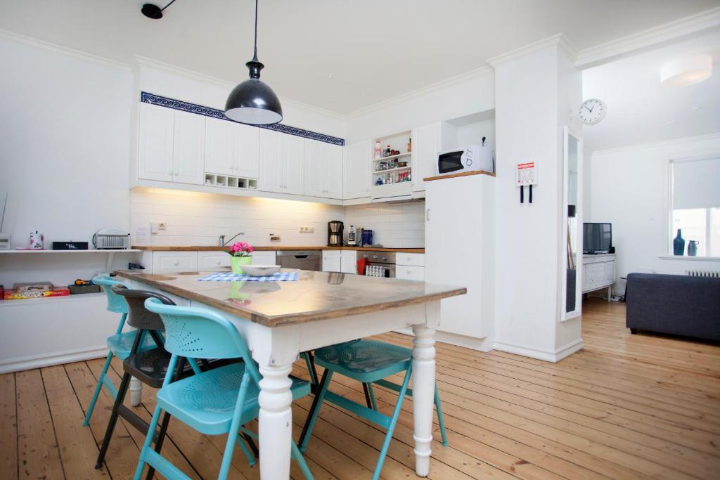uma cozinha com uma mesa de madeira e cadeiras azuis em Aska Apartment em Reykjavík
