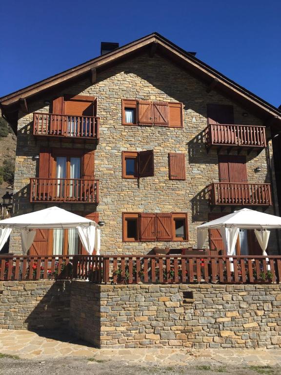 un edificio con dos sombrillas delante en Apartaments Alt Aneu Baqueira, en Isavarre