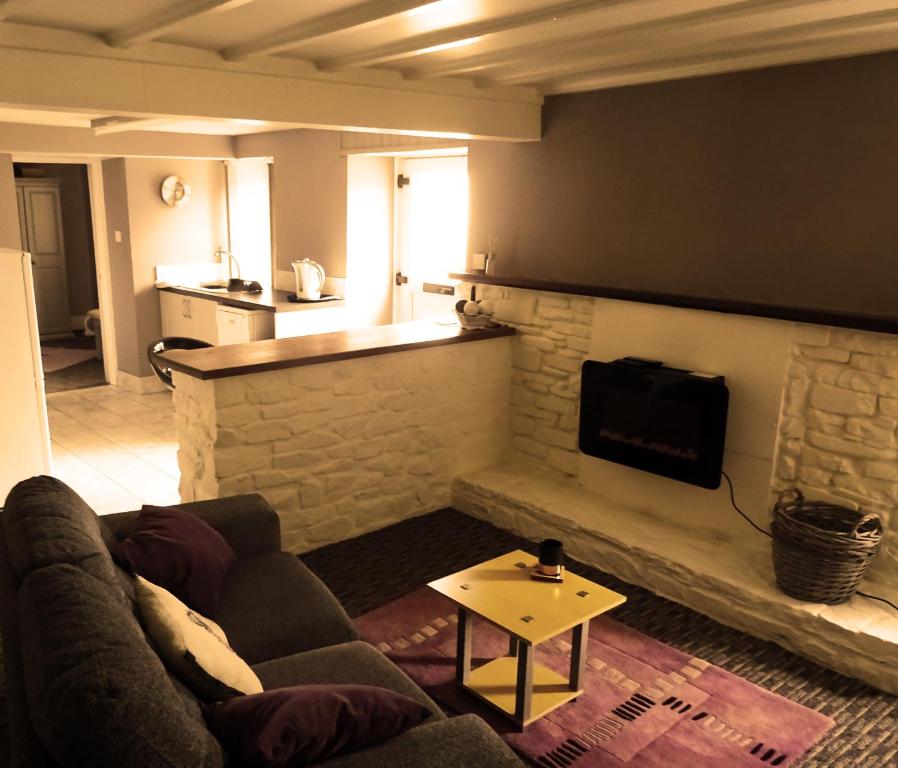 a living room with a couch and a stone fireplace at Beechwood House in New Quay