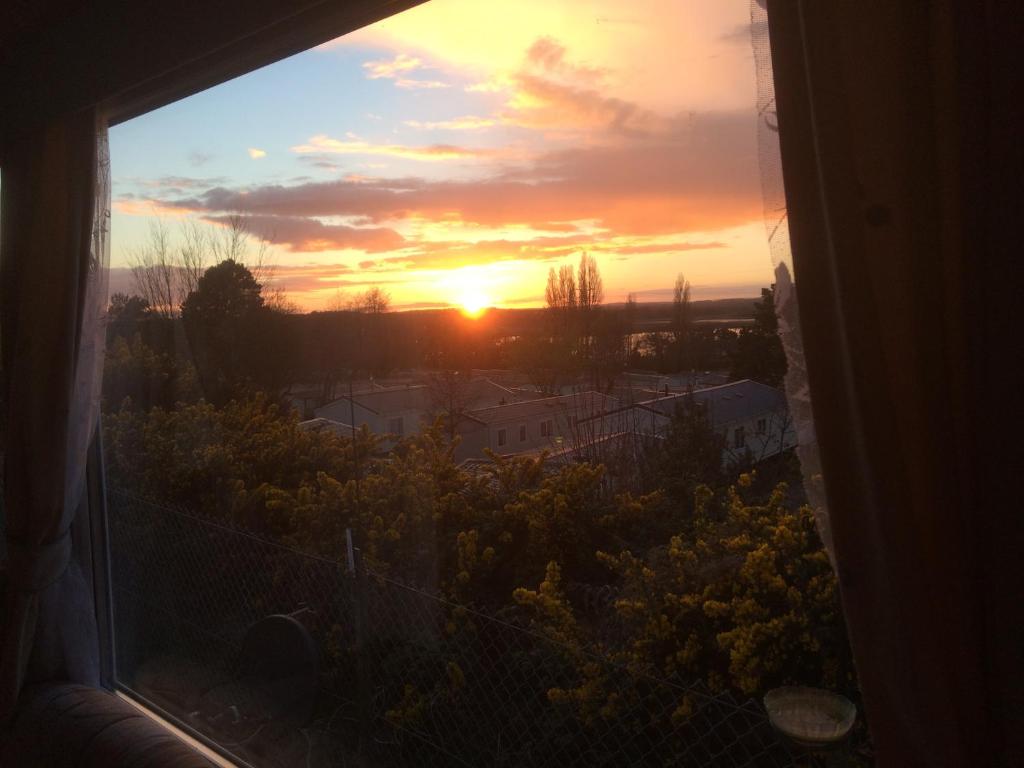 einen Sonnenuntergang aus einem Fenster eines Hauses in der Unterkunft Turlin Valley in Poole