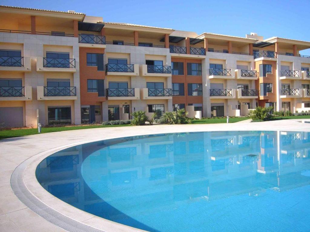 una grande piscina di fronte a un edificio di Apartamento Corcovada - By Bedzy ad Albufeira