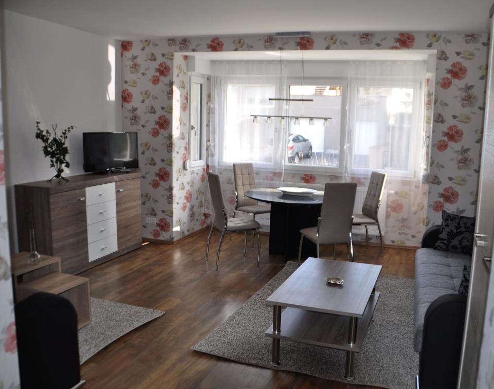 una sala de estar con una mesa y un sofá en Ferienwohnungen Haus Sauer, en Offenheim