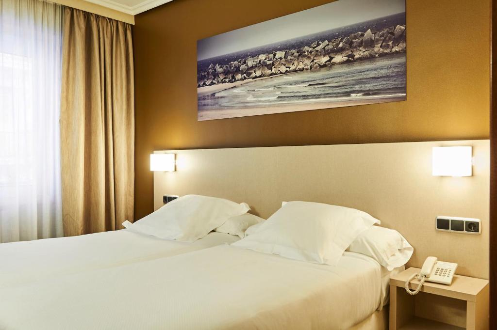 a hotel room with a bed and a telephone at Hotel Parma in San Sebastián
